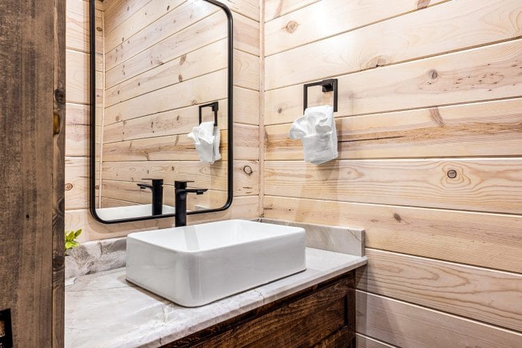 Half bath with a vessel sink and a black faucet