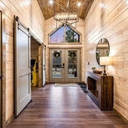 Hallway with a sliding barn door and a glass double door at the end