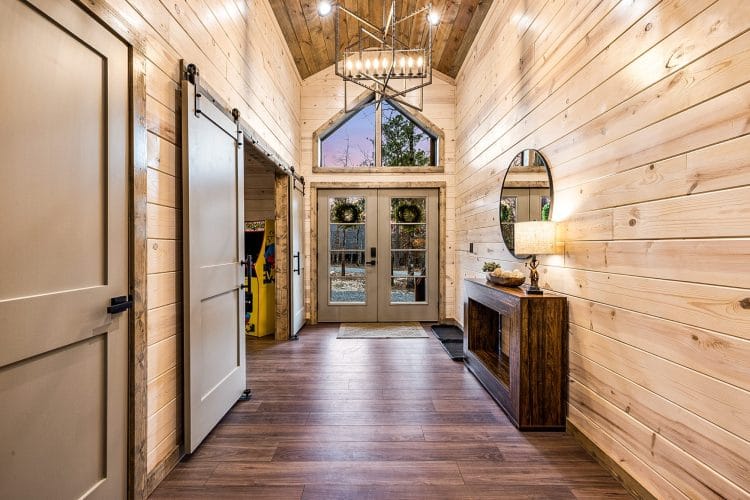 Hallway with a sliding barn door and a glass double door at the end