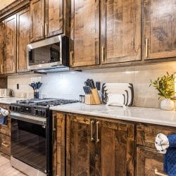 Kitchen counters with a stainless range and microwave under dark wood cabinets