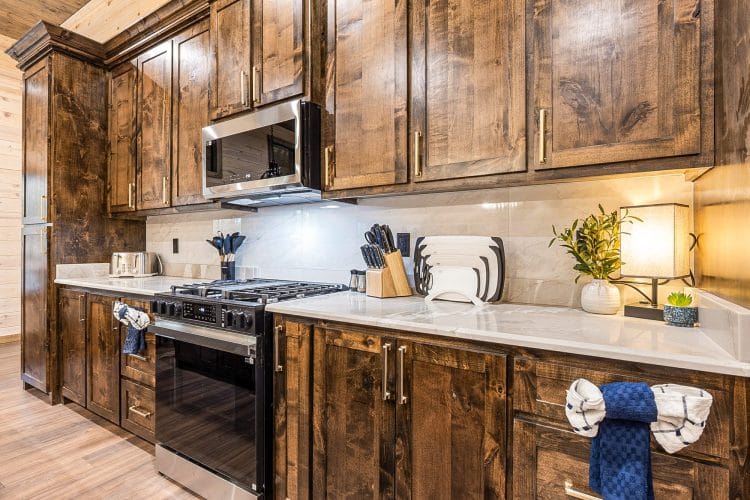 Kitchen counters with a stainless range and microwave under dark wood cabinets