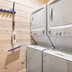 Stacked washer and dryer on a pine wall
