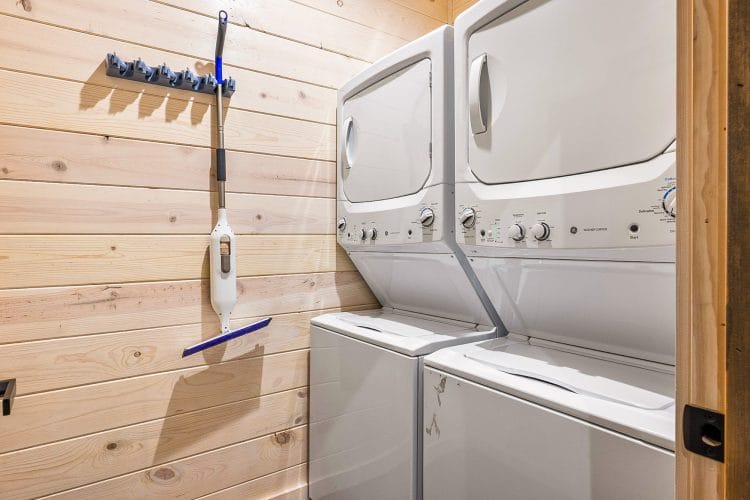 Stacked washer and dryer on a pine wall