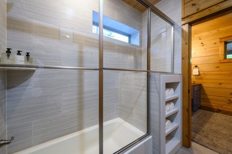 Tub-shower behind a glass door with a small window above