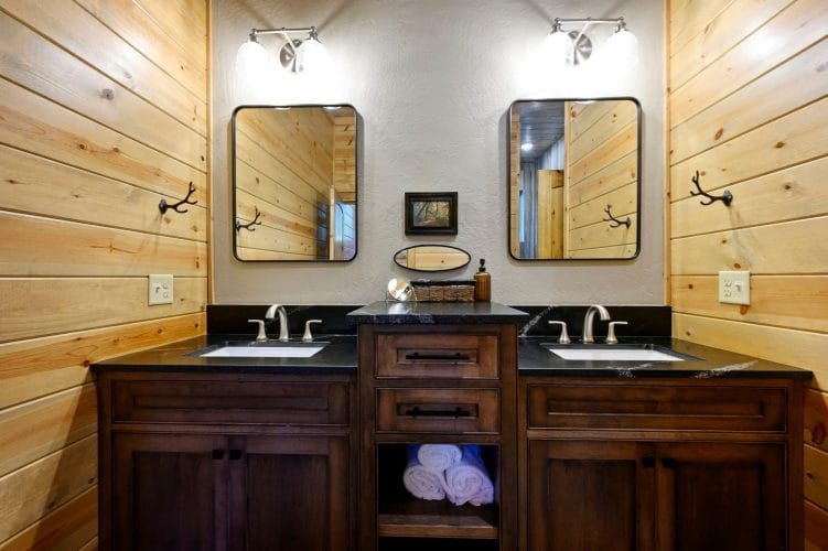 Double vanity with a black countertop and two matching mirrors