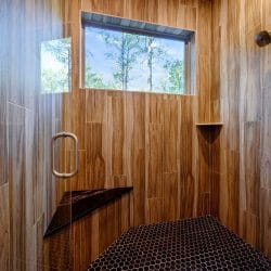 Walk-in shower with wood-look tile and a small window