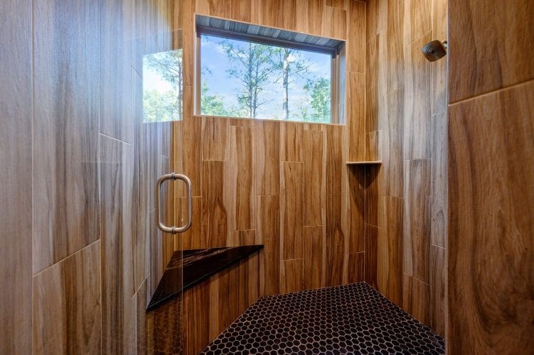 Walk-in shower with wood-look tile and a small window