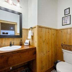 Half bath with a small vanity, round sink and toilet