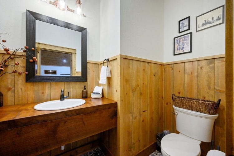 Half bath with a small vanity, round sink and toilet