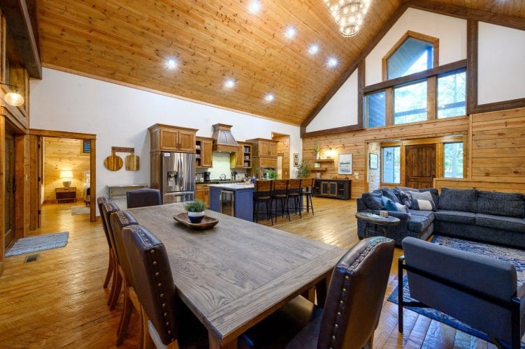 Dining table with leather chairs, kitchen and living room open behind it