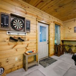 Dartboard on the wall next to an exterior door, bar stools to the right