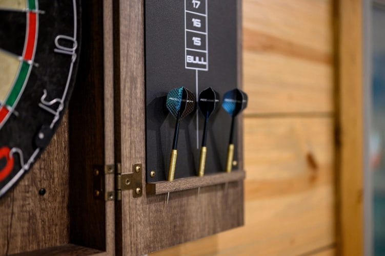 Dart set hanging on the dartboard cabinet
