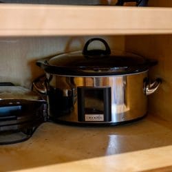Slow cooker and a small appliance stored in a kitchen cabinet