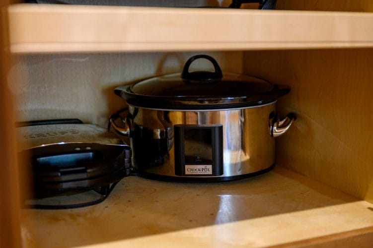 Slow cooker and a small appliance stored in a kitchen cabinet