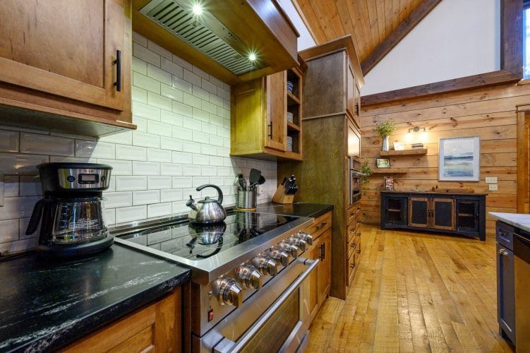 Range with a tile backsplash, drip coffee maker and tea kettle