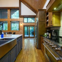 Kitchen sink and range with glass doors to the deck at the far end
