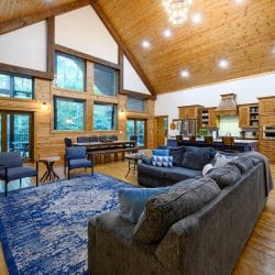 Living room sectional and blue armchairs with the open kitchen beyond
