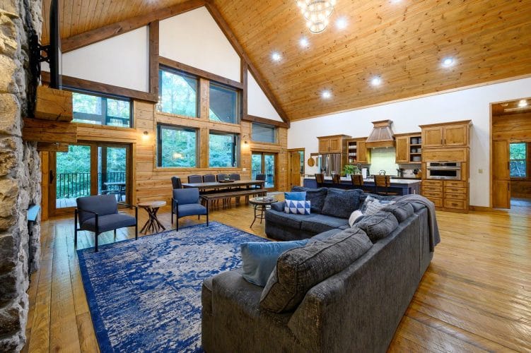 Living room sectional and blue armchairs with the open kitchen beyond