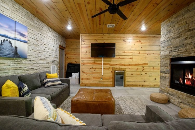Gray sectional and ottoman facing the TV in the lower-level living area