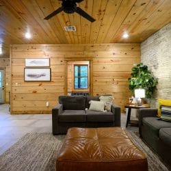 Lower-level seating area with a stone wall and the fireplace at the right