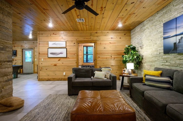 Lower-level seating area with a stone wall and the fireplace at the right