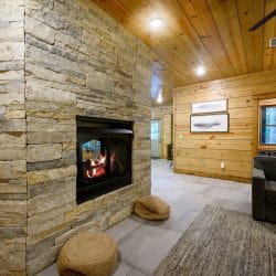 Stone double-sided fireplace with a hallway beyond