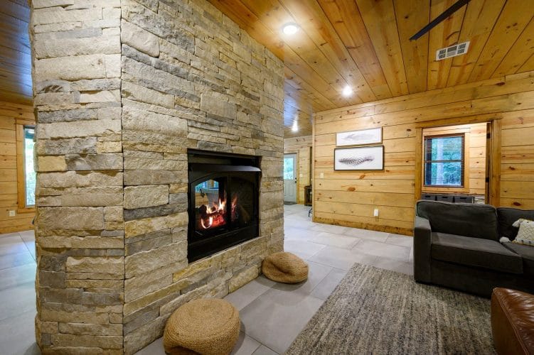 Stone double-sided fireplace with a hallway beyond