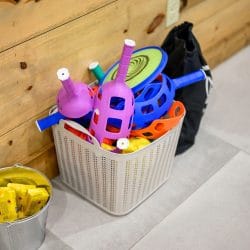 Basket of kids toys and a bucket on the floor