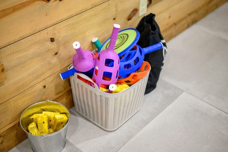 Basket of kids toys and a bucket on the floor