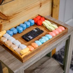 Tray of colorful foam pieces and a TV remote on a side table