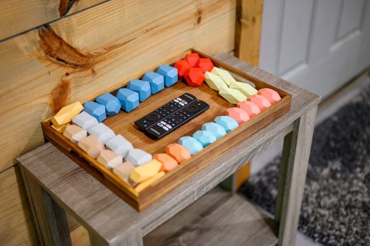 Tray of colorful foam pieces and a TV remote on a side table