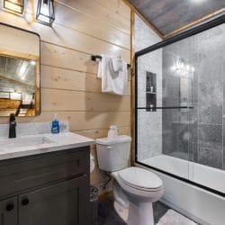 Bathroom with a tub-and-shower and gray tile wall
