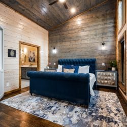 Main house king bedroom with a navy tufted sleigh bed on a blue patterned rug