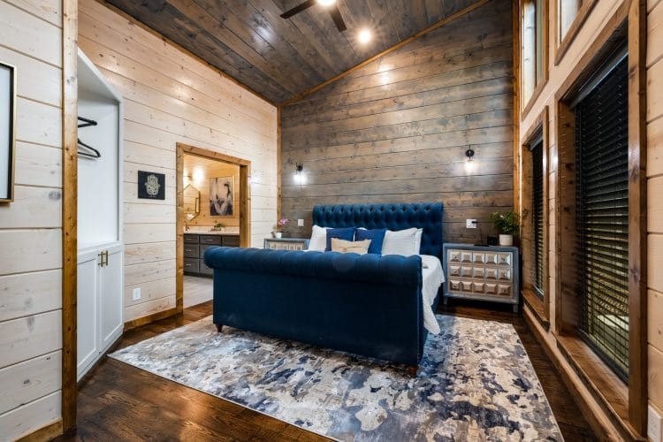 Main house king bedroom with a navy tufted sleigh bed on a blue patterned rug