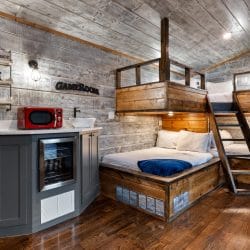 Built-in bunk nook with a loft bed above, a ladder and a bed below