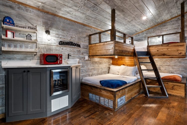 Built-in bunk nook with a loft bed above, a ladder and a bed below