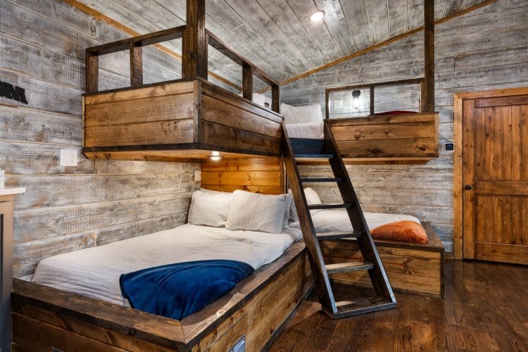 Closer view of the built-in bunk with a ladder and navy bedding