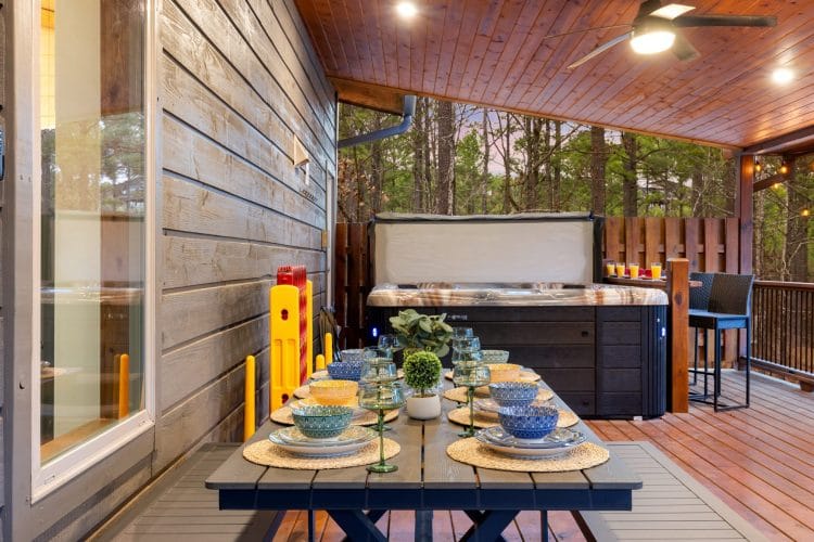 Covered deck with the hot tub behind a long table
