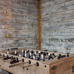 Foosball table against a gray plank wall