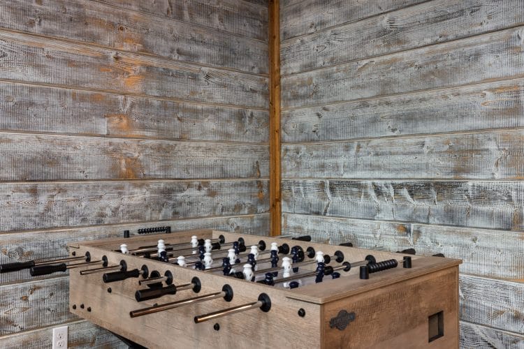 Foosball table against a gray plank wall