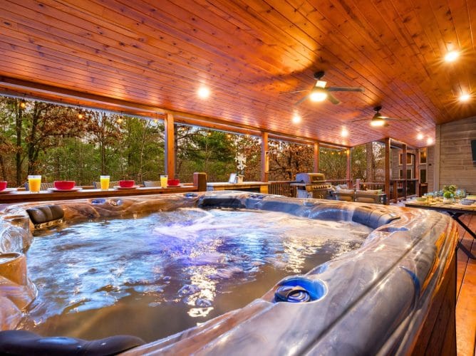 Hot tub on the covered deck beside a bar-height counter, under a pine ceiling