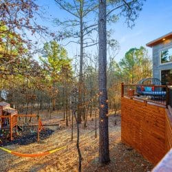 Playset and a hammock between trees with the deck at the right