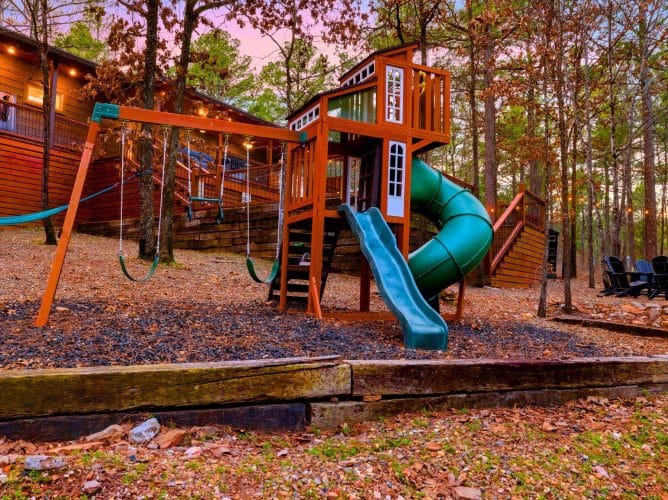 Playset with a spiral slide and swings on mulch