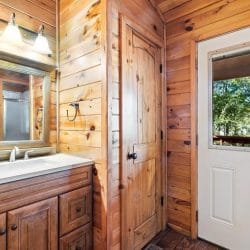 Bathroom vanity with a mirror beside a window door