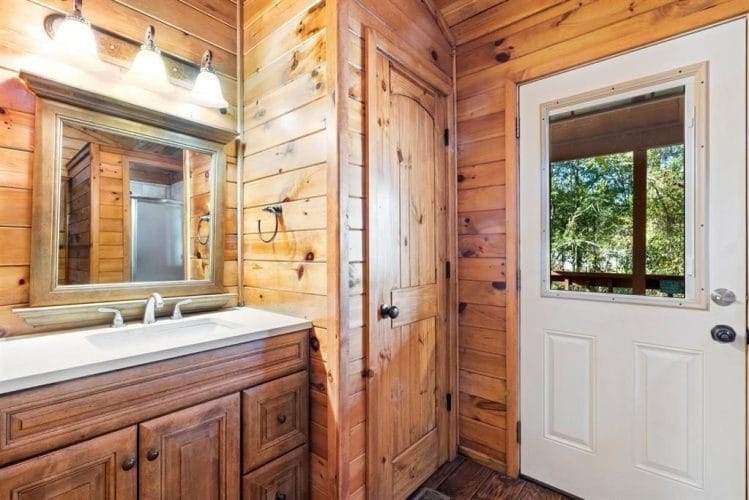 Bathroom vanity with a mirror beside a window door