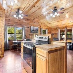 Small dining table with chairs under the windows, open to the stove counter and living room