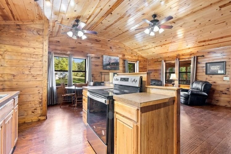 Small dining table with chairs under the windows, open to the stove counter and living room
