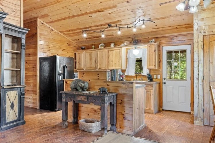 Kitchen seen from the living room with the refrigerator, cabinets and a back door with a window