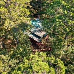 Aerial view of the green metal roof among thick trees