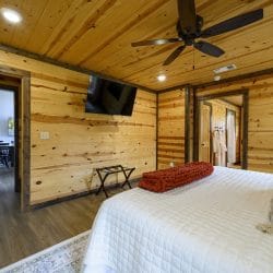 Same bedroom with a wall TV and a doorway toward the dining area